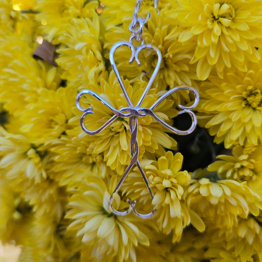 handmade twisted wire design on hand-forged silver cross pendant with heart by Sterling Roots