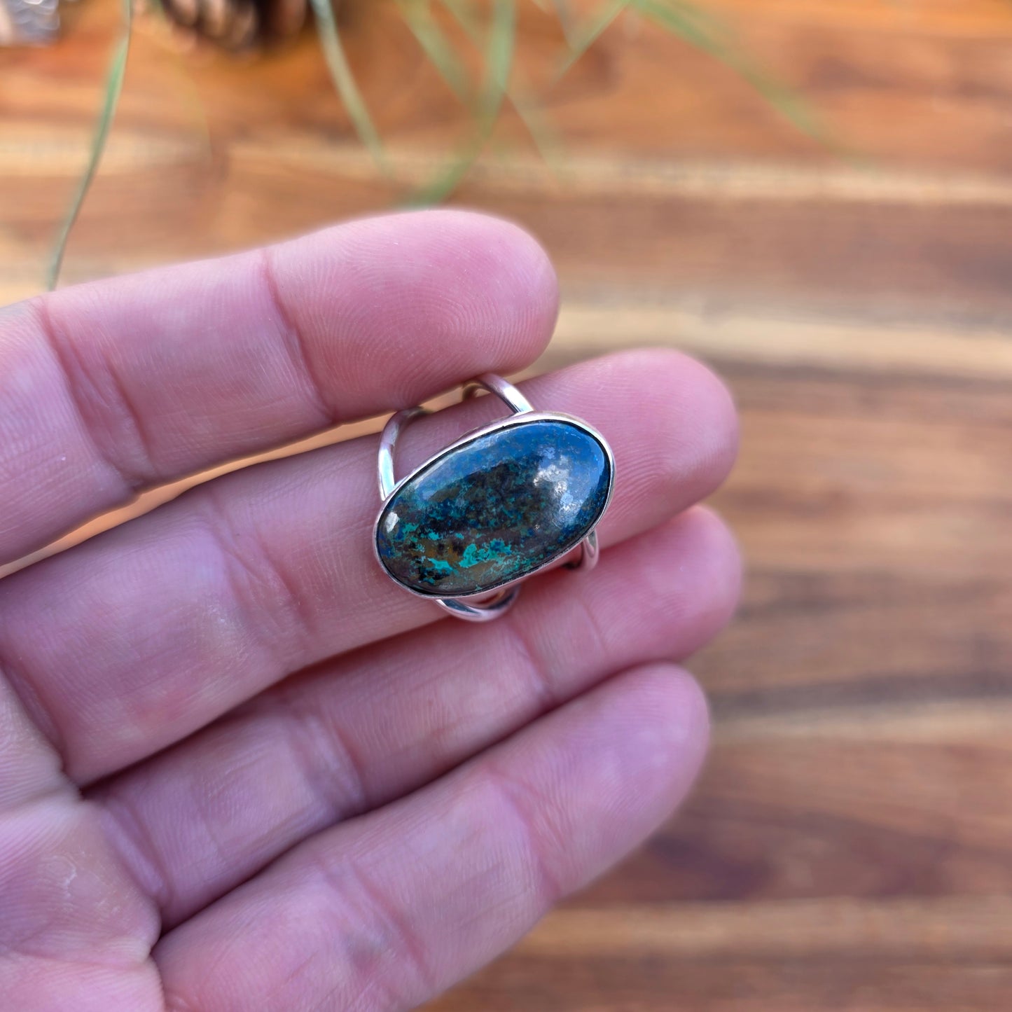 Green and blue azurite ring with a polished finish and split shank, designed with a clean, minimal form displayed on finger.