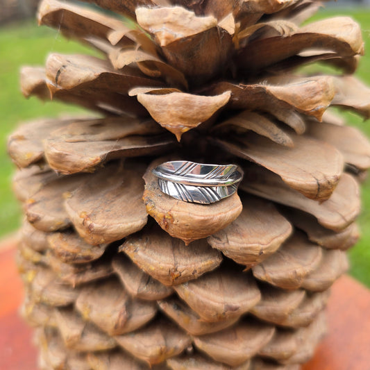 sterling silver feather leaf ring shown from front view on pinecone