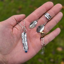 Load image into Gallery viewer, feather pendant with oil Czech glass, leaf ring, and leaf threader earrings displayed together on hand