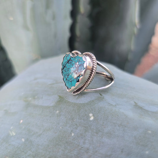 Sterling silver and turquoise heart ring displayed in natural setting side angle.