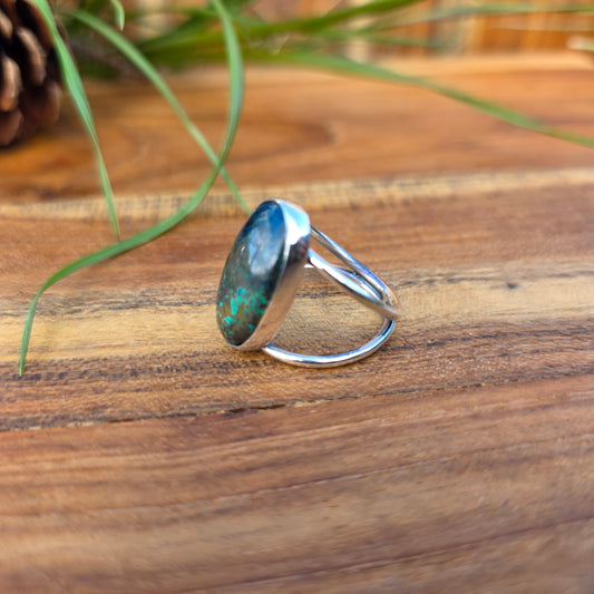 One-of-a-kind azurite ring with green and blue tones, a polished surface, and a split shank design side angle.