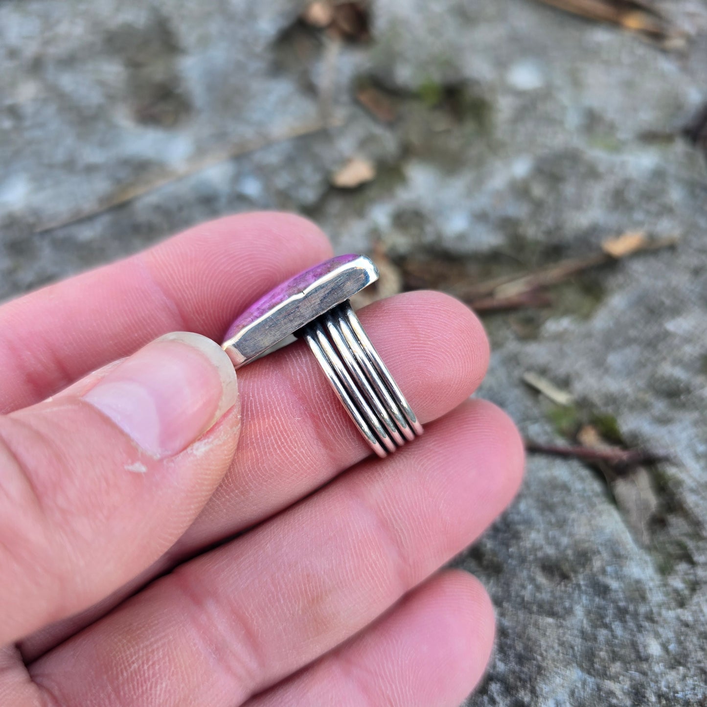 silver triple shank ring with pink stone displayed on hand
