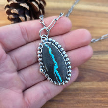 Load image into Gallery viewer, Sterling and Royston Ribbon turquoise pendant displayed on hand