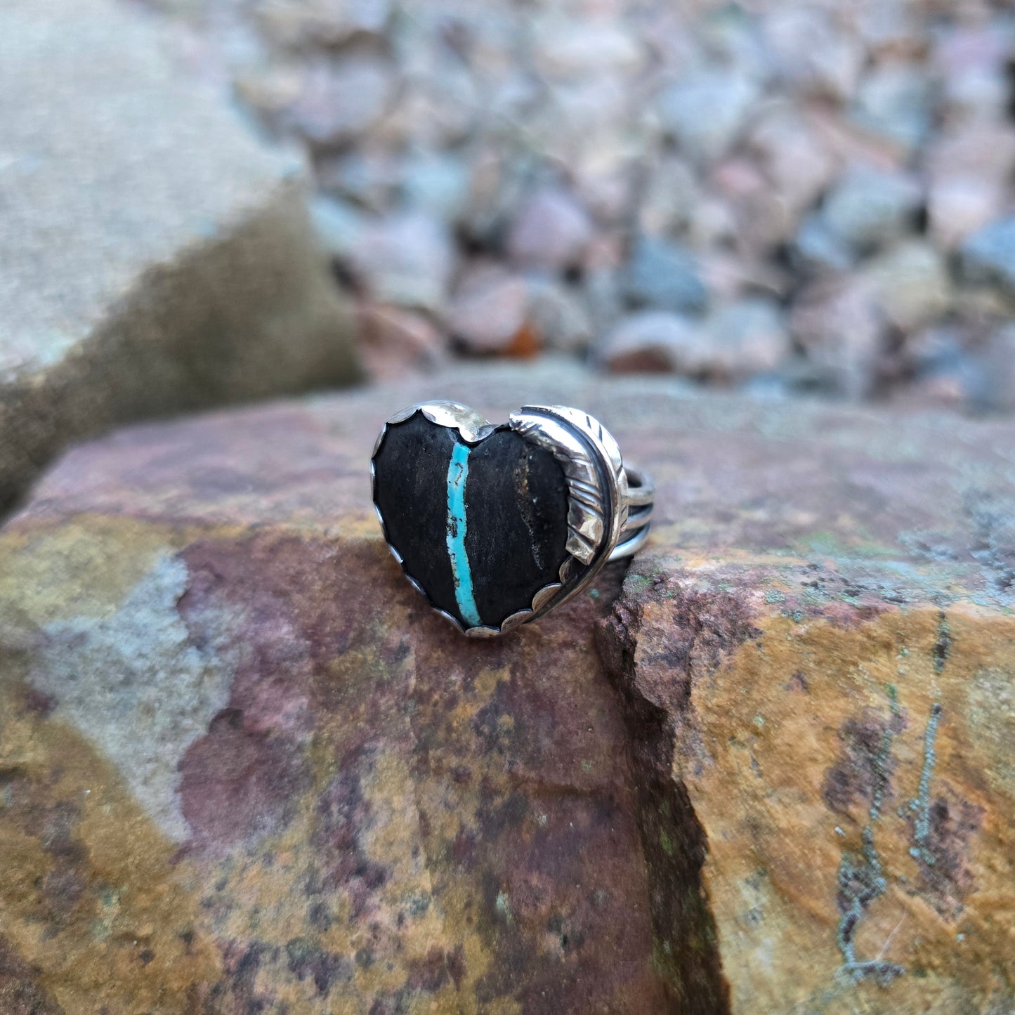 close-up of turquoise ribbon running through black royston ribbon heart ring