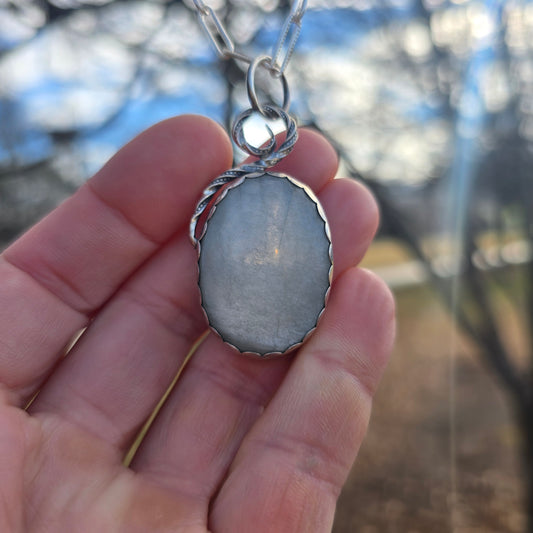 silver and white moonstone statement pendant displayed on hand