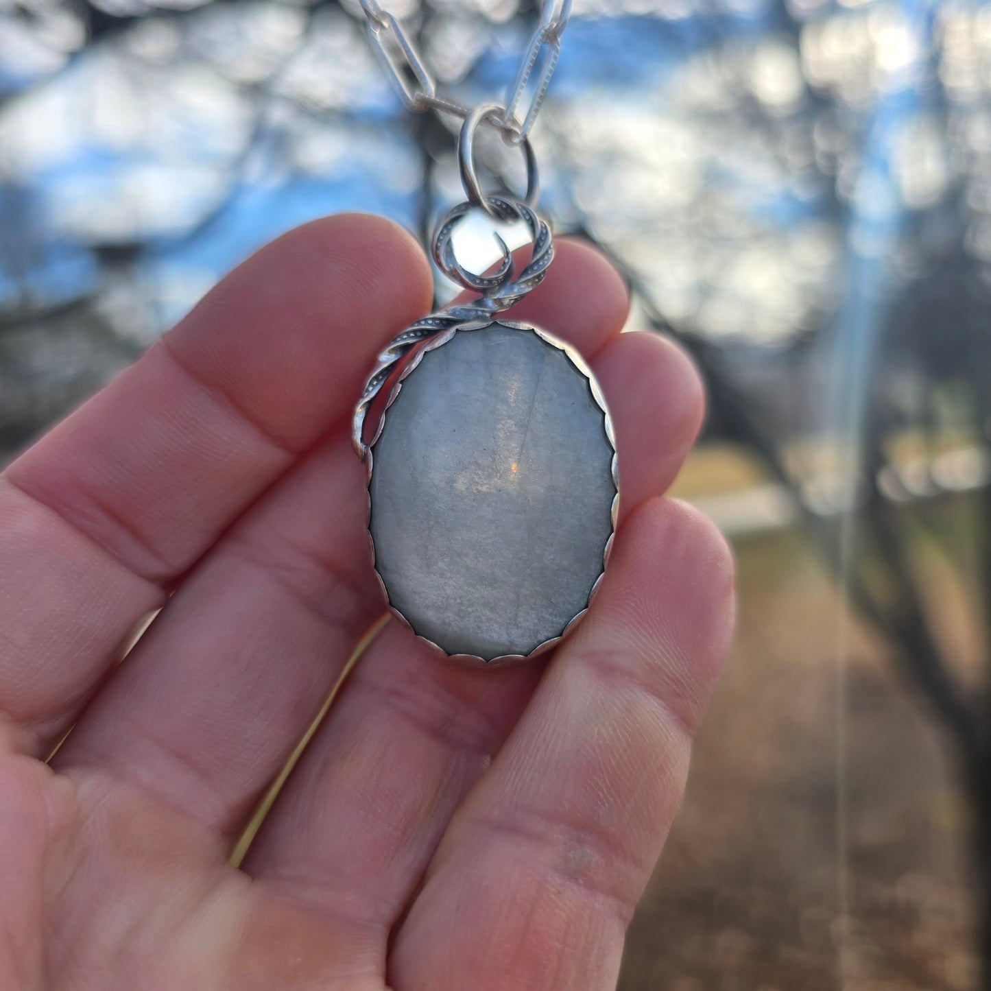 silver and white moonstone statement pendant displayed on hand