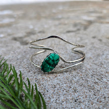 Load image into Gallery viewer, Front view of a sterling silver cuff bracelet set with an oval malachite stone and finished with a polished surface.