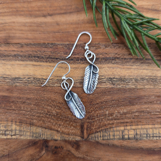 top view of sterling silver feather earrings measuring about 1.5 inches