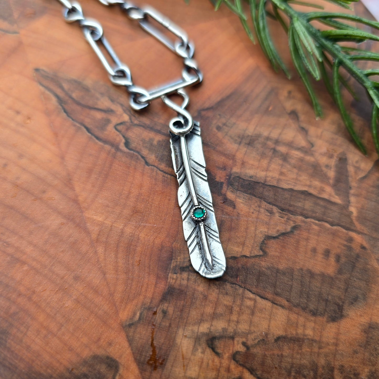 Sterling silver feather pendant with green glass