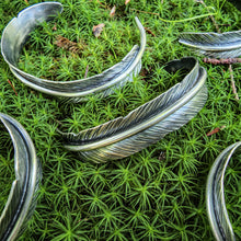 Load image into Gallery viewer, collection of silver feather cuff bracelet collection on moss