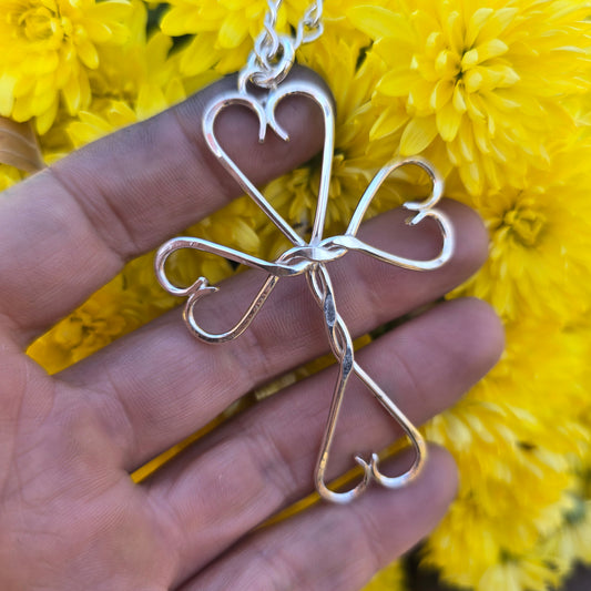hand-forged sterling silver cross pendant with twisted wire and heart-shaped ends — Sterling Roots Jewelry.