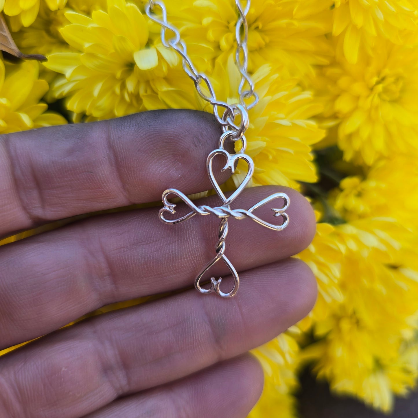 Adirondack-made sterling silver cross with hearts — small scale, heirloom quality.