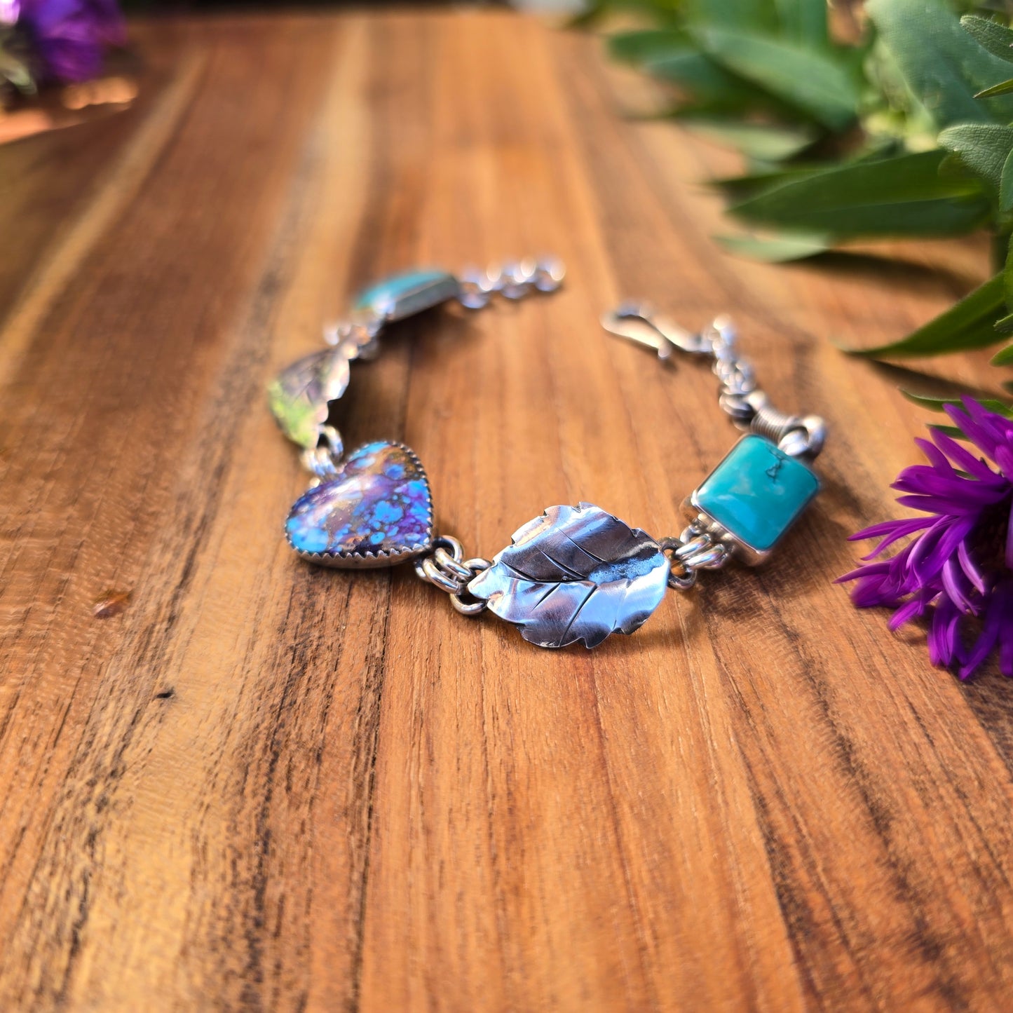 Close-up of textured sterling silver hearts and turquoise links in a handcrafted bracelet by Northern New York silversmith Emily Dicob.