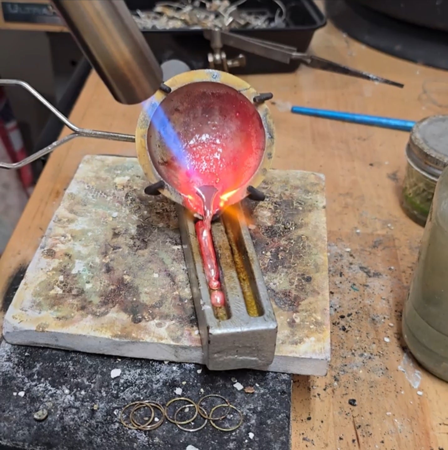 Silversmiths pouring sterling silver ingot in Adirondack studio.