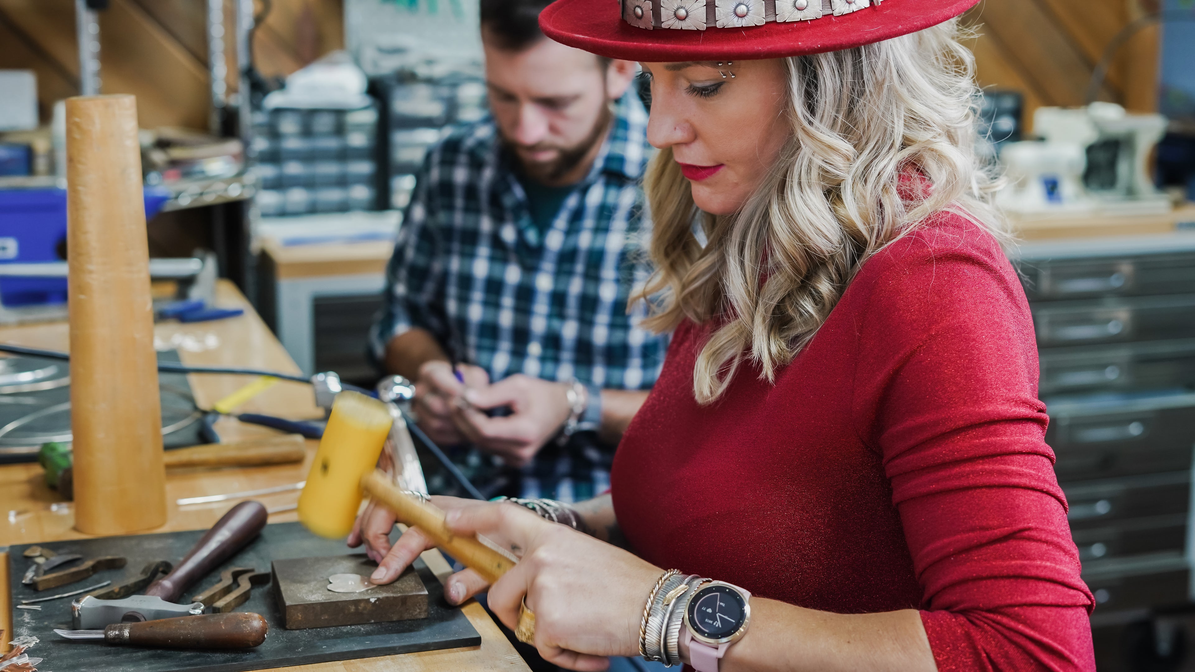 Emily and Shane Dicob of Sterling Roots forging their foundational pieces of jewelry at workbench.