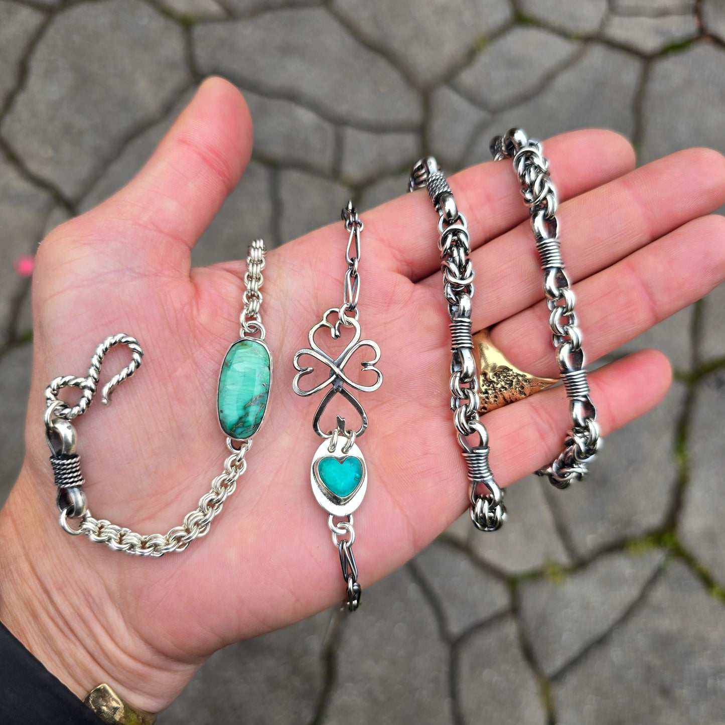 verisite chainmail bracelet, turquoise heart bracelet, and heavy men’s silver chain displayed together on hand