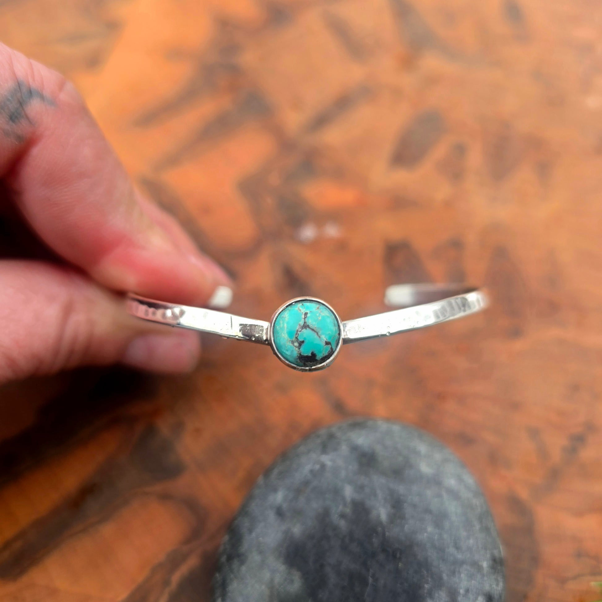 Detail of turquoise stone set in V-shaped silver cuff
