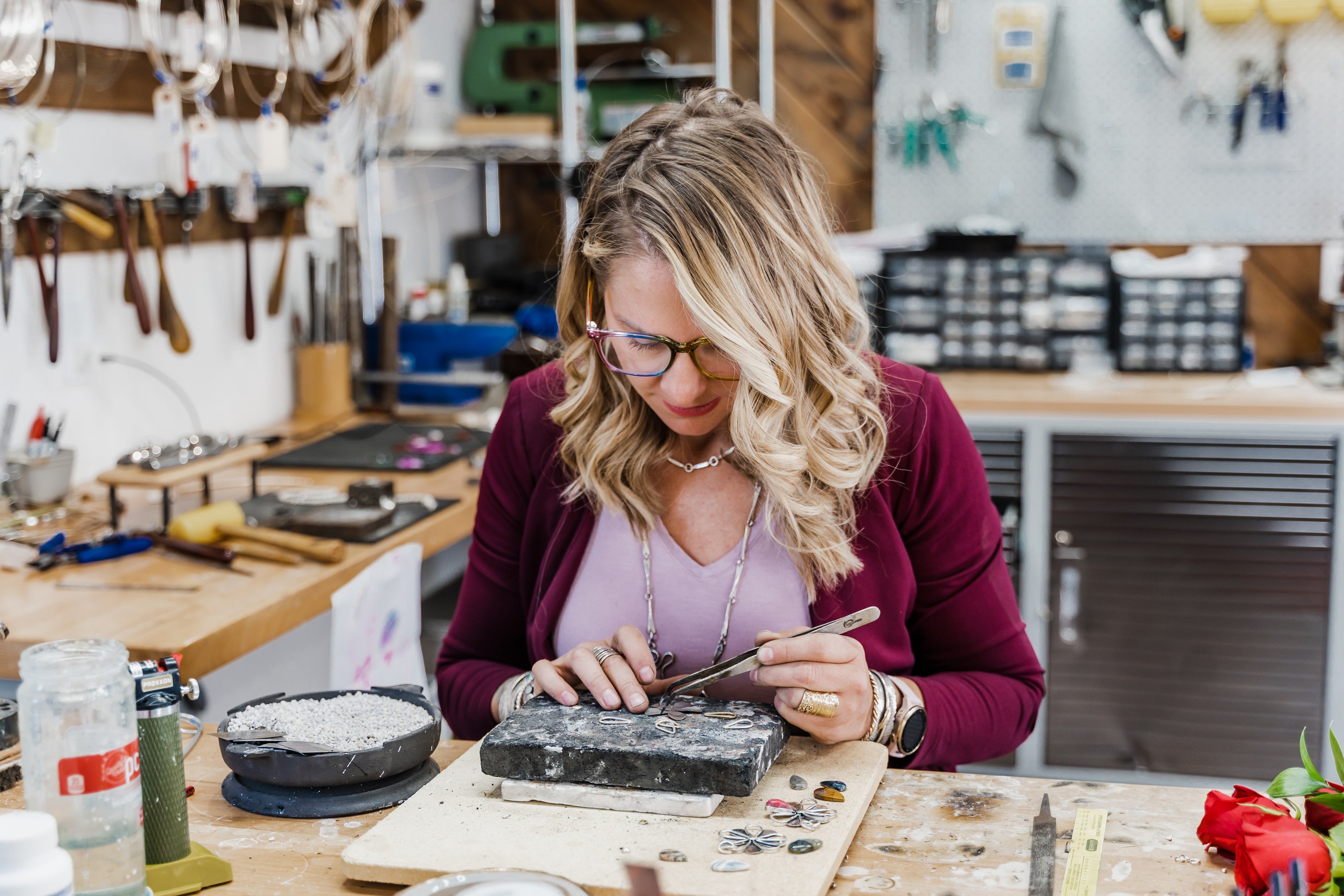 Emily Dicob, silversmith, forging sterling silver jewelry at workbench in Adirondack Foothills studio.