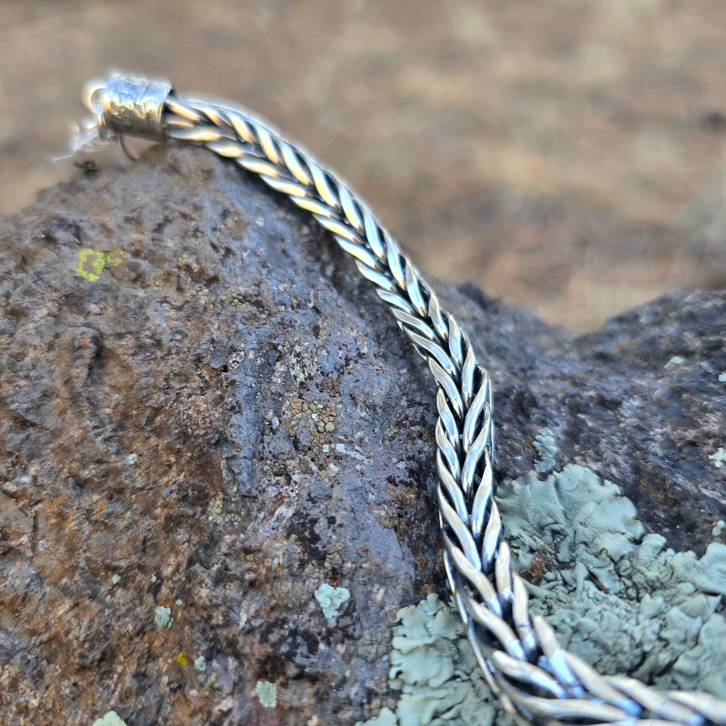 Handwoven sterling silver foxtail chain bracelet with reticulated silver end caps and a handmade clasp, built one piece at a time and sized for a 7.5–8 inch wrist.