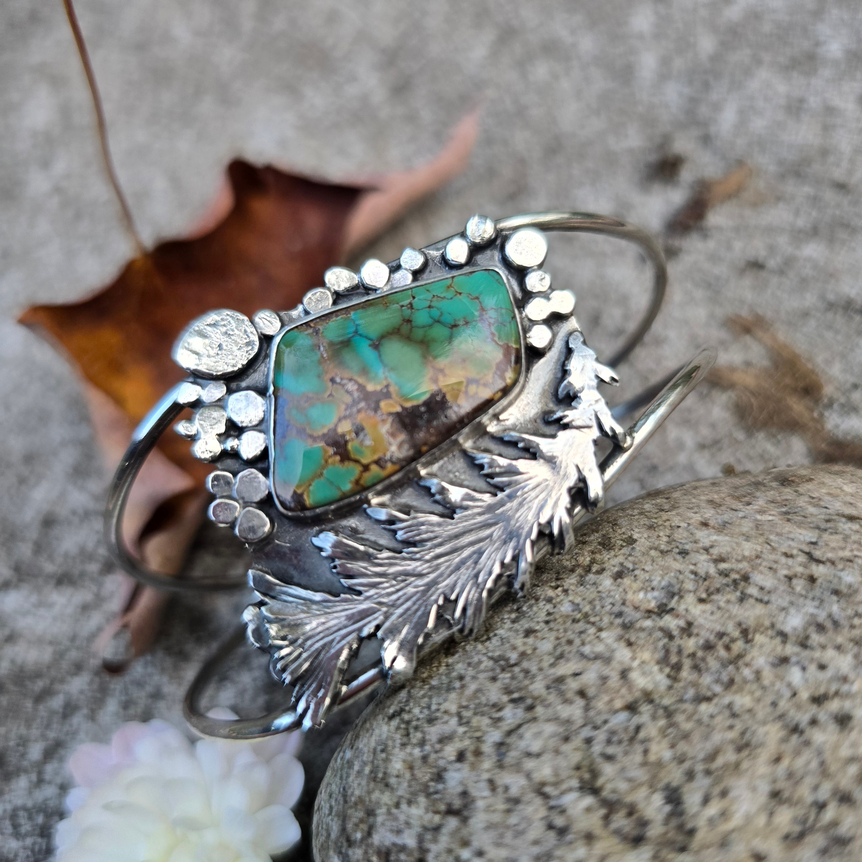 Hand-forged sterling silver and turquoise cuff bracelet featuring a hand-sawn tree built by silversmith, Emily Dicob.