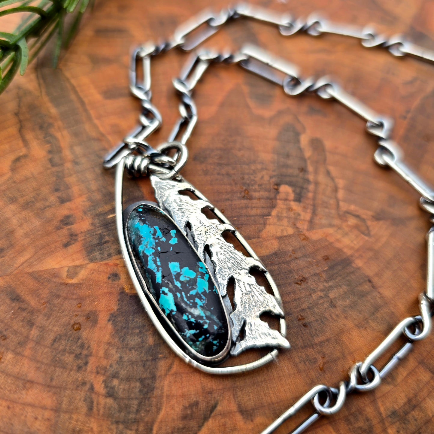 Detail of hand sawn tree form and turquoise in silver pendant