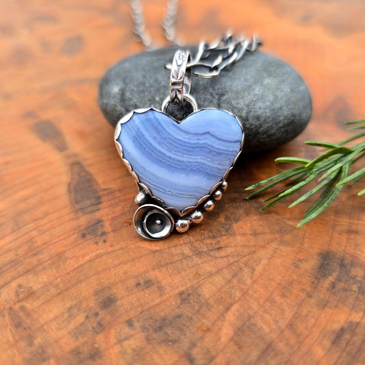 Heart shaped crazy lace agate pendant with flower accent in sterling silver