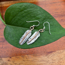 Load image into Gallery viewer, Front view of hand-forged mixed-metal feather earrings with sterling silver feathers and copper stems.
