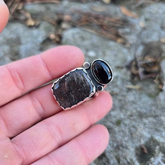 black and silver ring displayed on finger