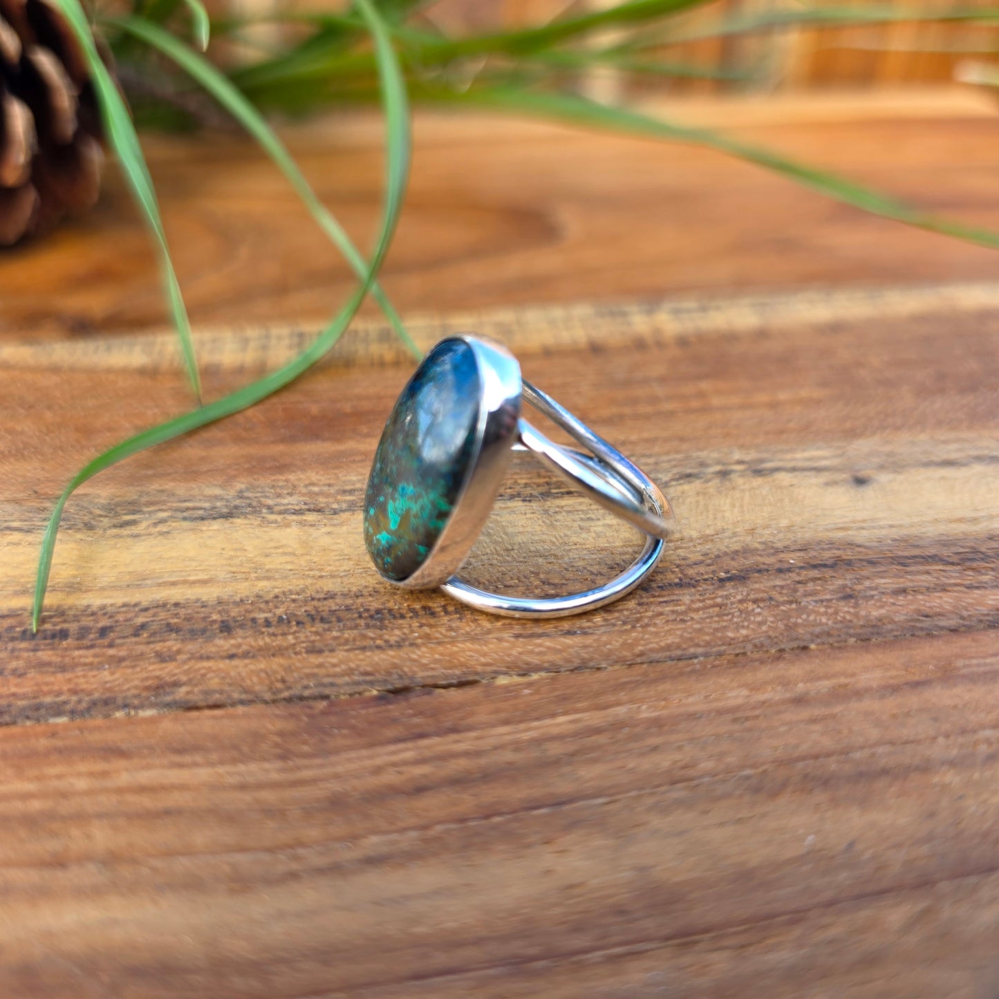 One-of-a-kind azurite ring with green and blue tones, a polished surface, and a split shank design side angle.