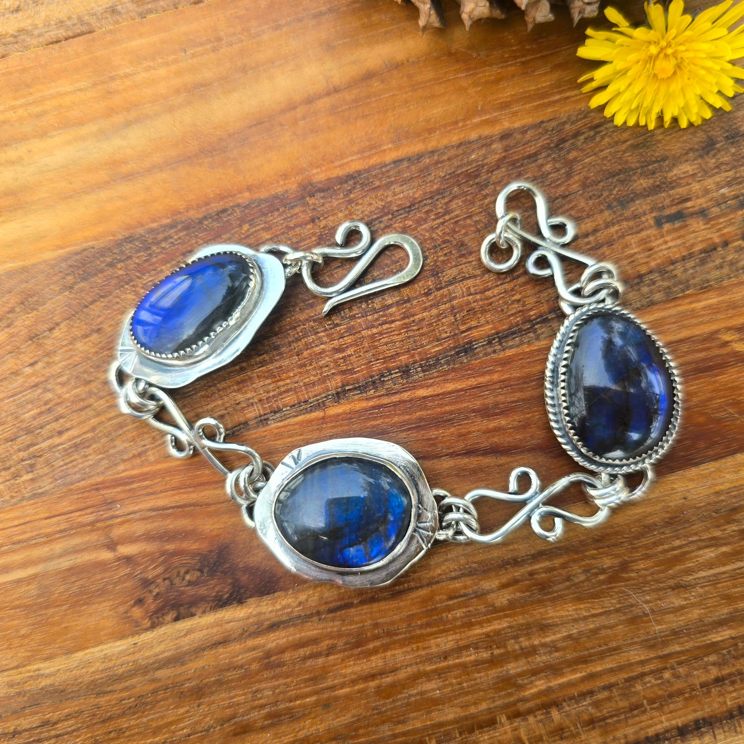 Sterling silver bracelet with three oval labradorite stones set along a handmade chain bracelet.