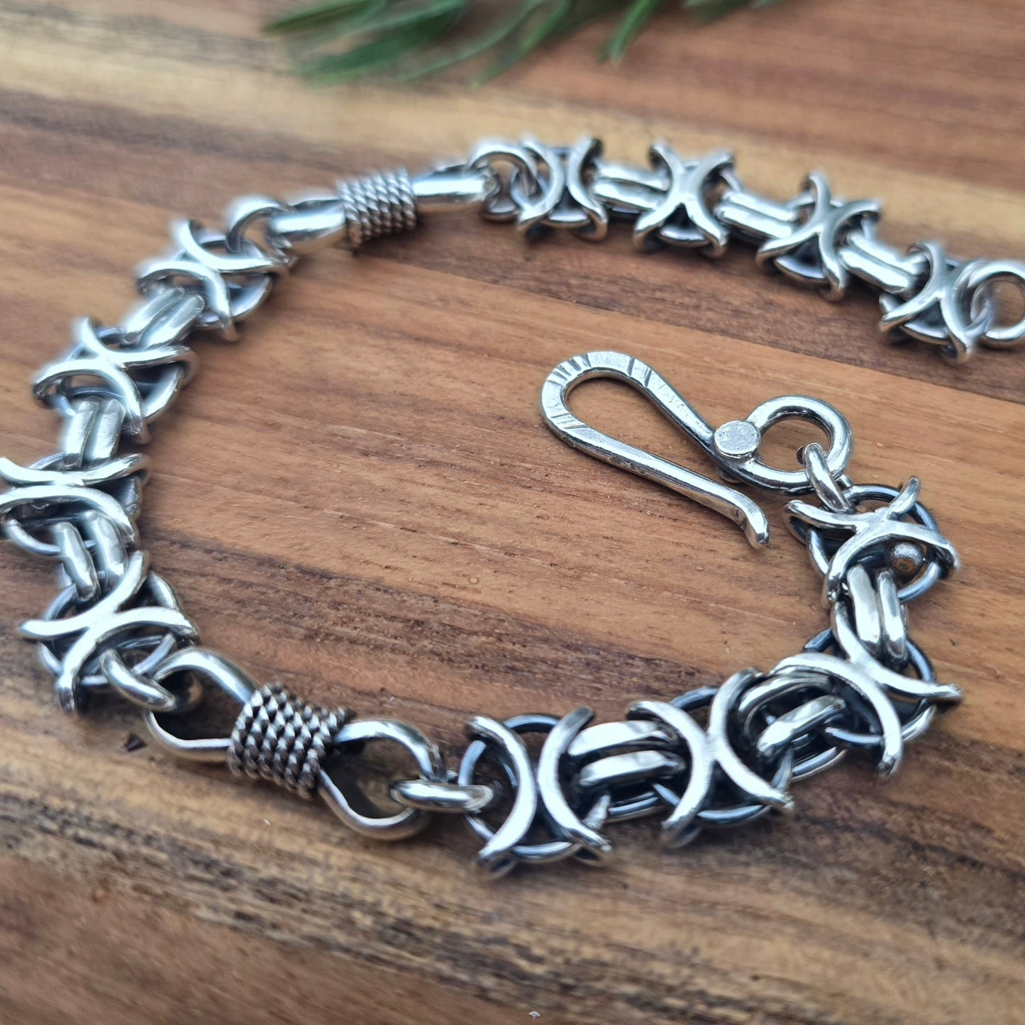 Detail of X O and bowtie links in oxidized sterling silver bracelet