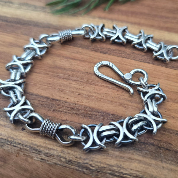 Detail of X O and bowtie links in oxidized sterling silver bracelet