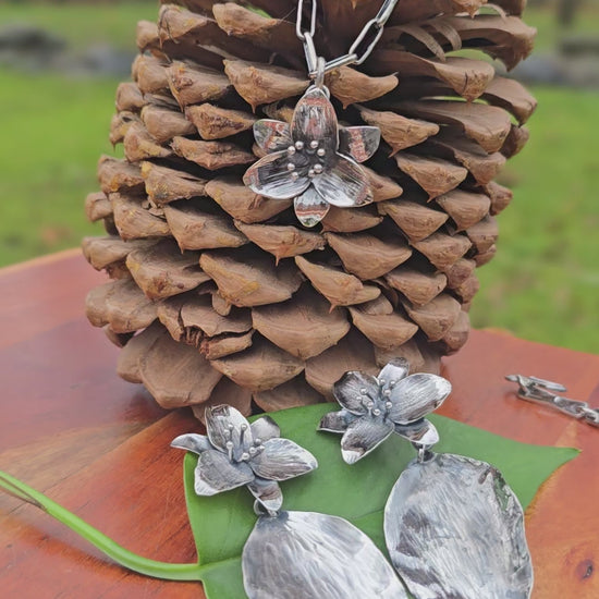 video showing sterling silver trillium pendant, three-trillium necklace, and large trillium earrings with leaf drops