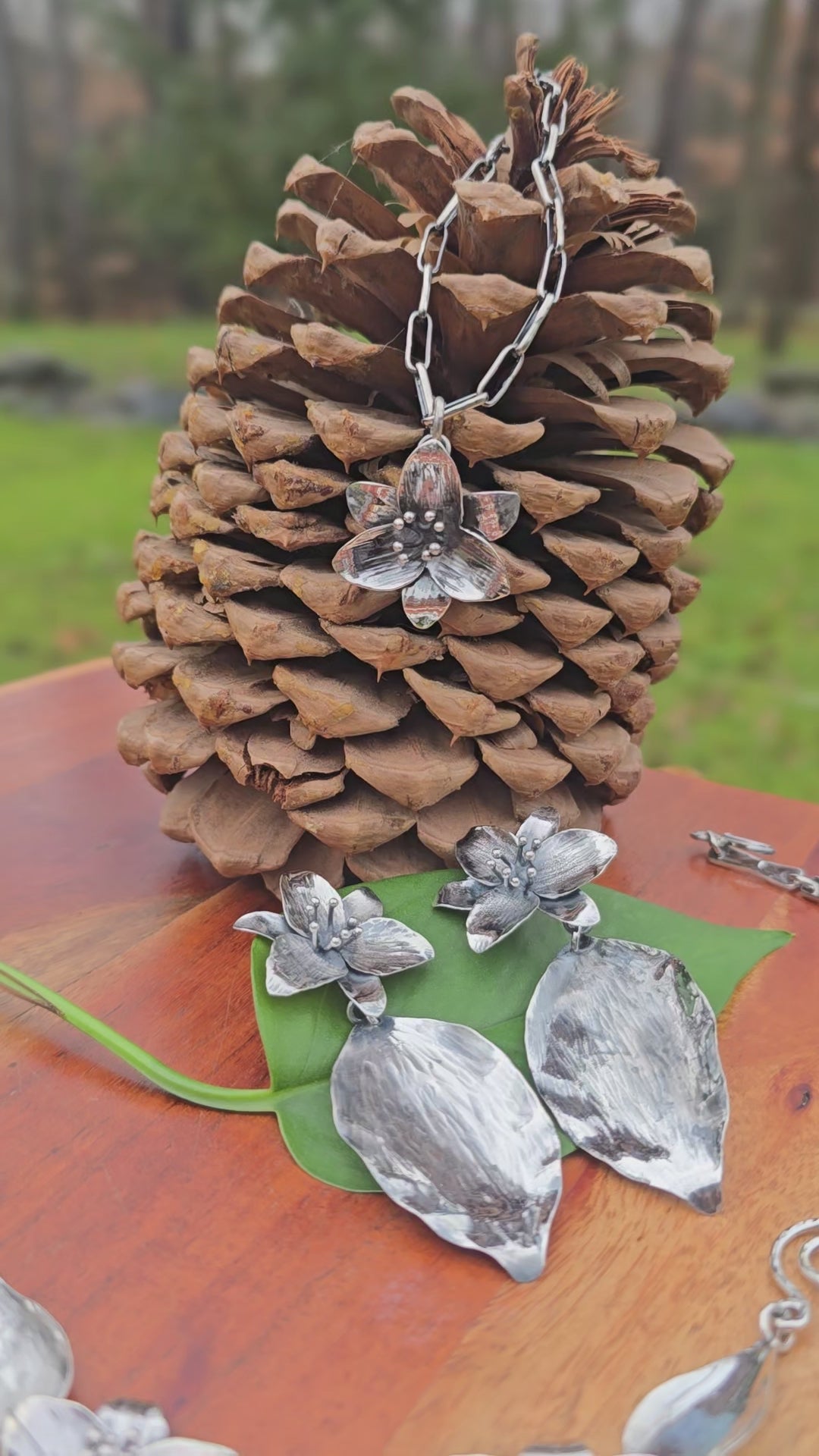 video showing sterling silver trillium pendant, three-trillium necklace, and large trillium earrings with leaf drops