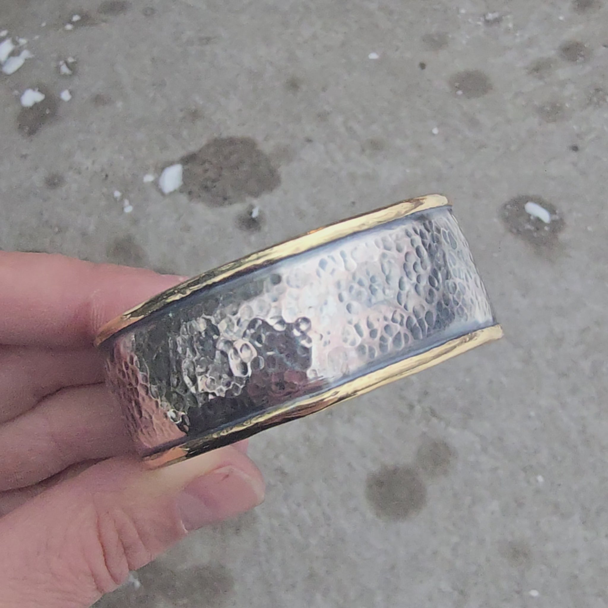 Sterling silver hammed cuff with bronze perimeter rotating in hand