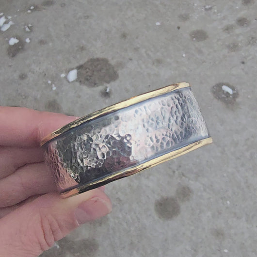 Sterling silver hammed cuff with bronze perimeter rotating in hand