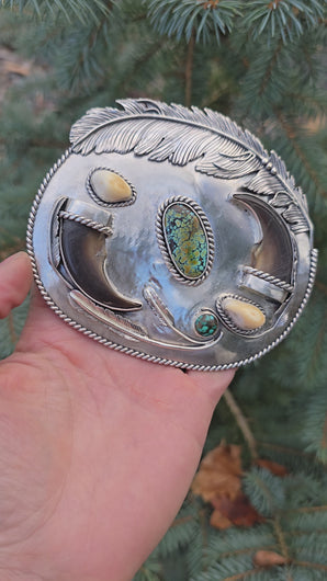 sterling silver belt buckle with turquoise centerpiece, elk ivory accents, feather and bear claw design full view