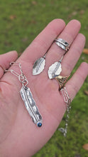 Load and play video in Gallery viewer, video showing feather pendant with oil Czech glass, leaf ring, and leaf threader earrings displayed together
