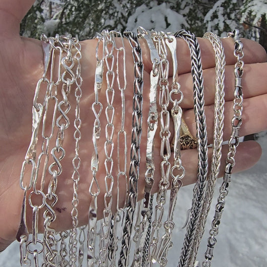 collection of sterling silver chains oxidized and shiny displayed across rotating hand
