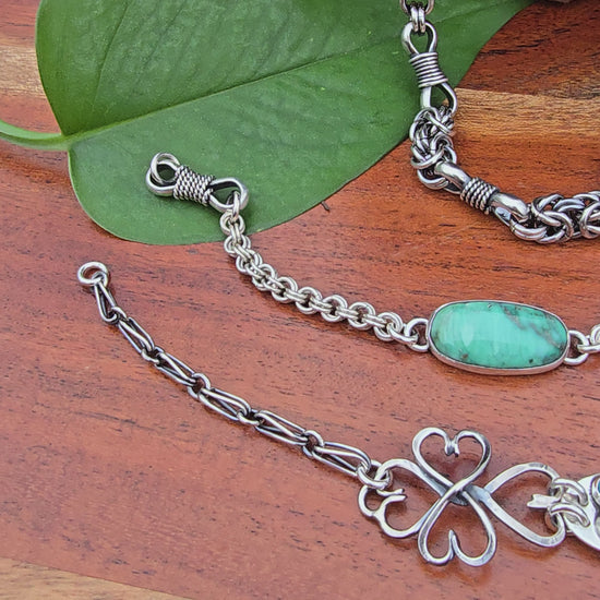 sterling silver verisite chainmail bracelet, turquoise heart bracelet, and heavy men’s chain displayed together