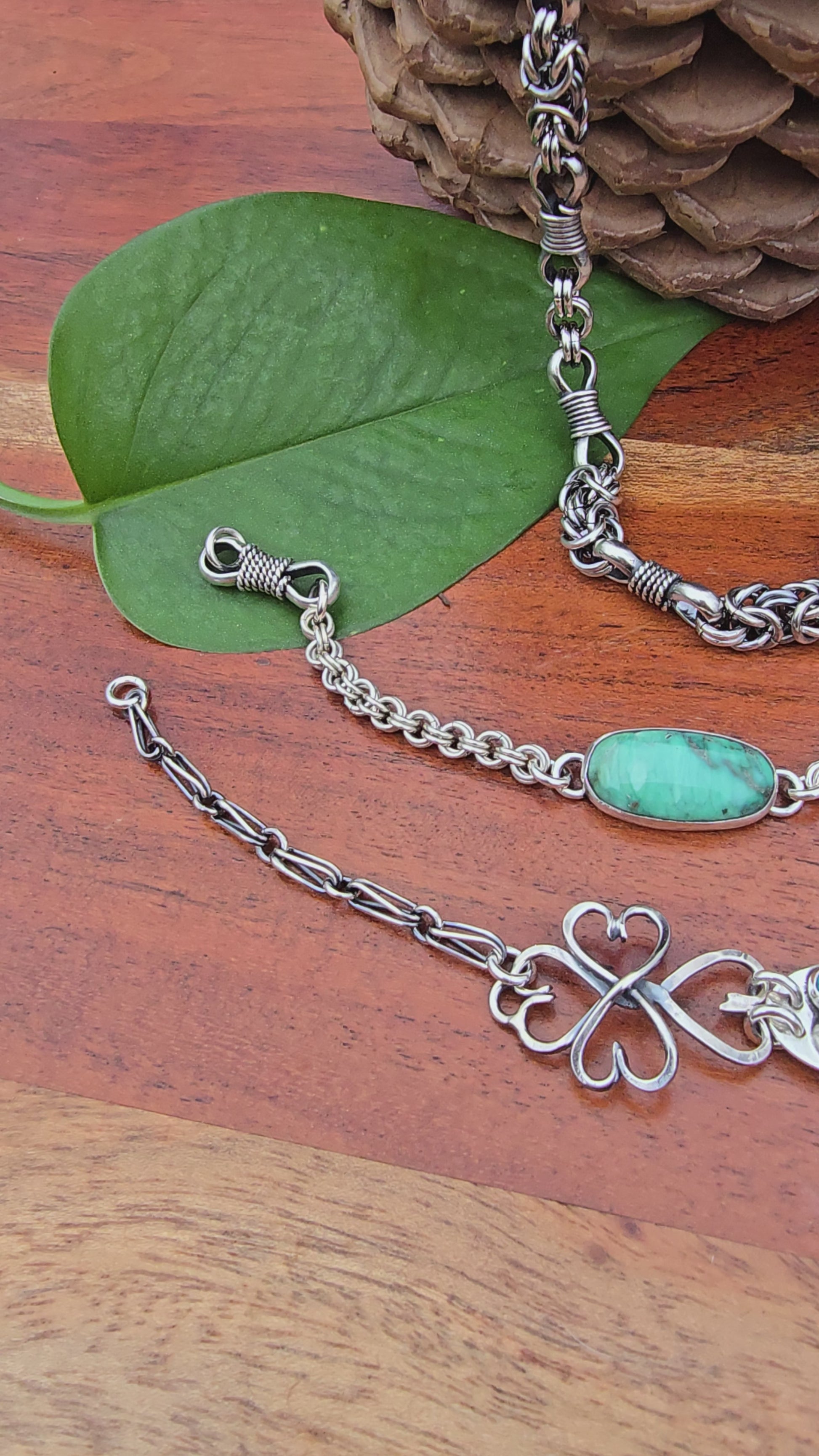 sterling silver verisite chainmail bracelet, turquoise heart bracelet, and heavy men’s chain displayed together