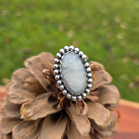 Close-up of the handcrafted rainbow moonstone ring with a bold beaded sterling silver perimeter
