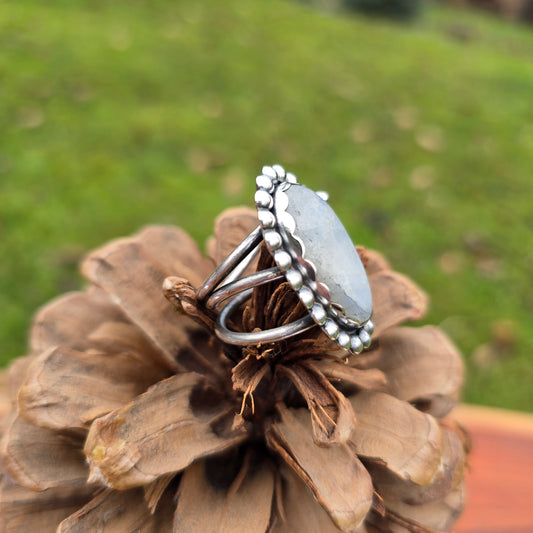 Close-up of the handcrafted rainbow moonstone ring with a bold beaded sterling silver perimeter side view