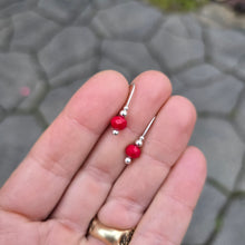 Load image into Gallery viewer, handmade red agate holiday earrings displayed on hand
