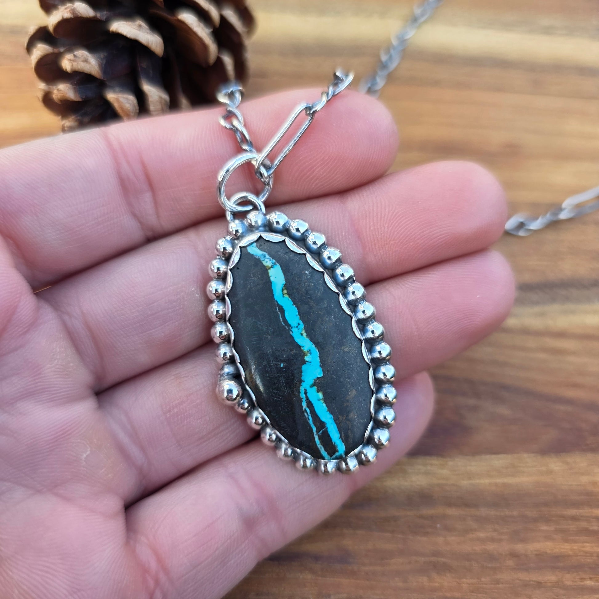 Sterling and Royston Ribbon turquoise pendant displayed on hand
