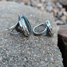 Load image into Gallery viewer, angled view of heart-shaped royston ribbon turquoise ring wrapped with silver feather
