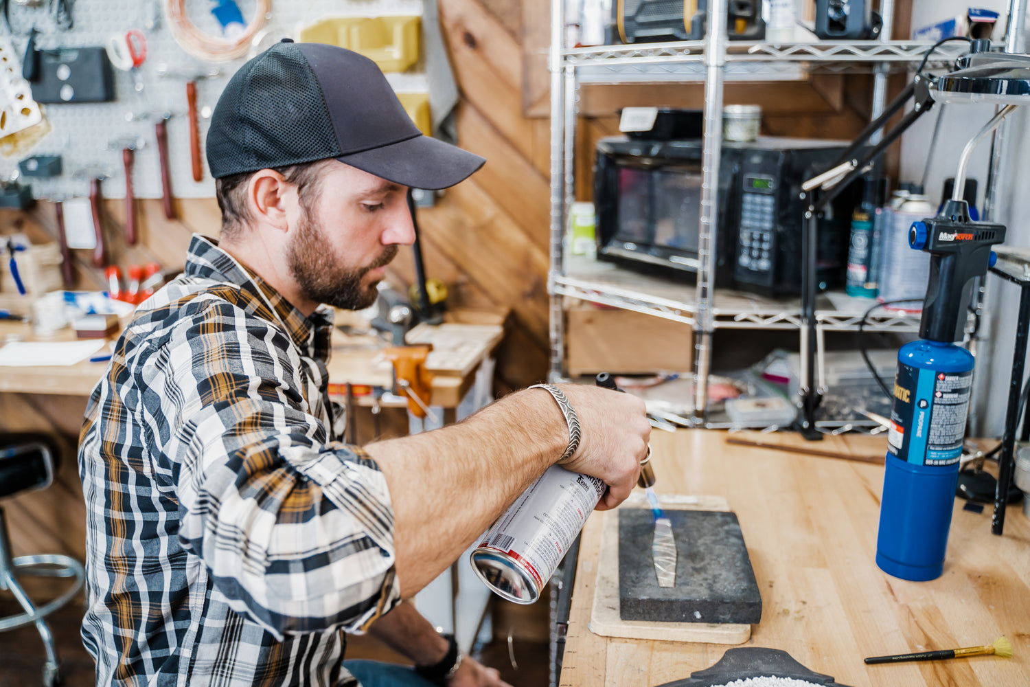Adirondack silversmith applying builder precision to hand-forged jewelry construction in Sterling Roots  studio.