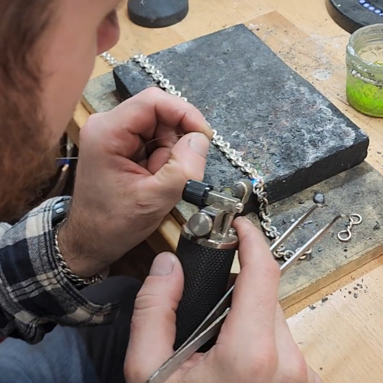 Traditional chainmaking process in a hand-forged jewelry studio by true chainmakers at bench.