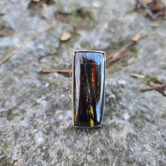 brown tiger iron rectangle stone ring displayed on rock